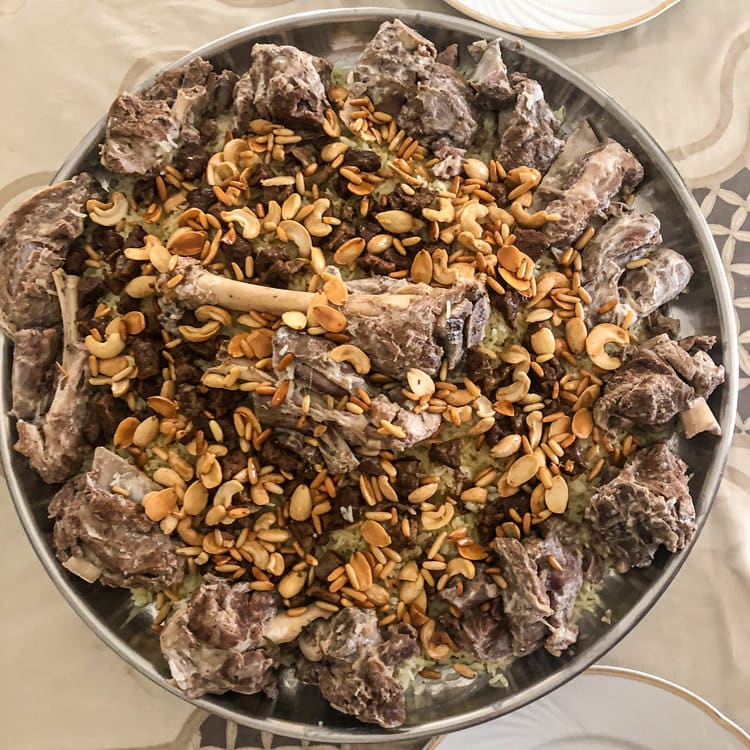 A platter of traditional Jordanian mansaf served with lamb and almonds over rice.