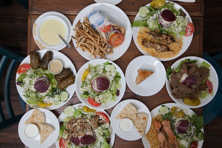A classic taverna spread featuring small plates, char-grilled meats, and cold beverages.