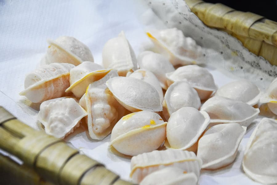 Ovos moles de Aveiro served in thin wooden barrels or host paper.
