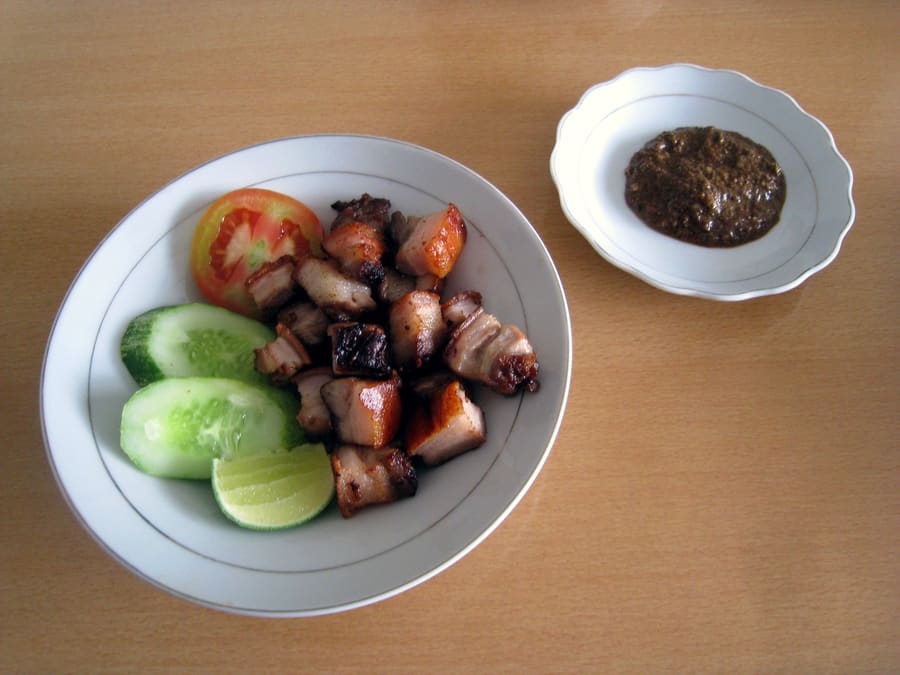 Babi guling served with crispy skin, lawar, and steamed rice.