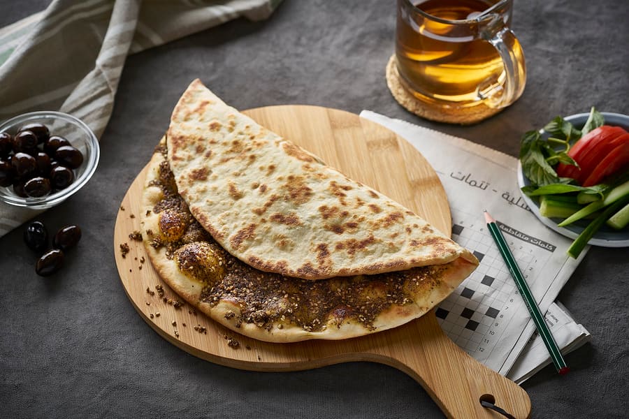 Fresh manakish flatbread topped with za'atar herbs and olive oil from a neighbourhood bakery.
