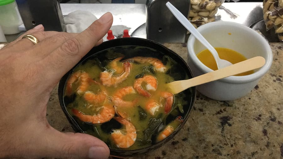 Tacacá served hot in a calabash bowl with tucupi, jambu, and dried shrimp.