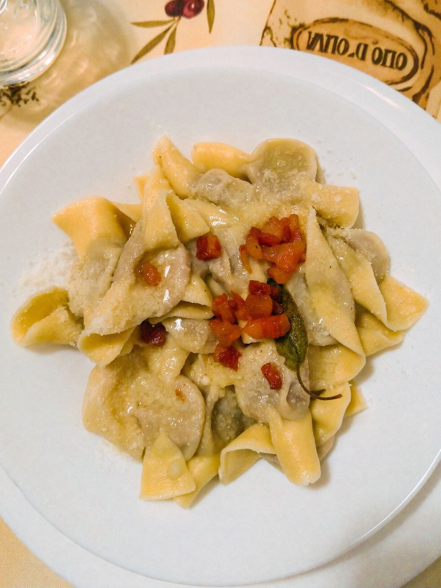 Casoncelli alla bergamasca served with melted butter, crispy pancetta, and fresh sage.