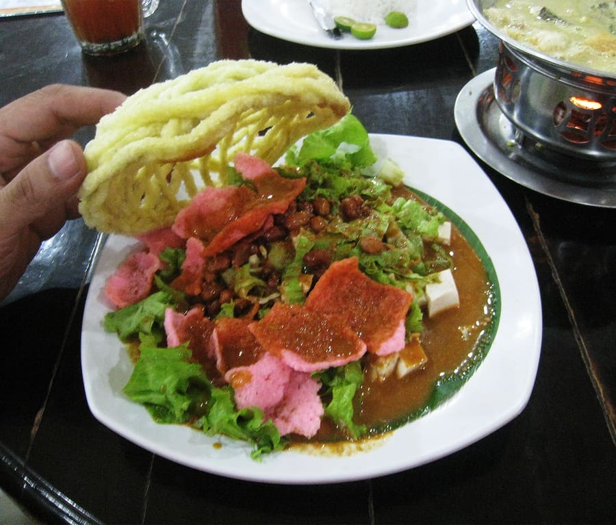 Asinan Bogor combines crunchy preserved vegetables or tropical fruits with a sharp chili and vinegar broth.