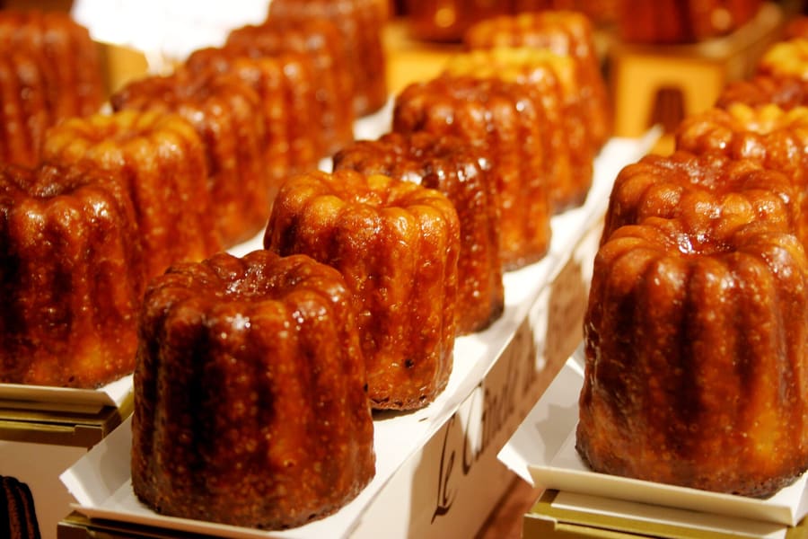 Canelés bordelais feature a dark caramel shell and soft rum-vanilla interior.