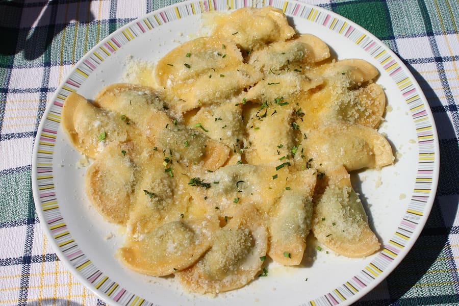 Schlutzkrapfen stuffed with spinach and ricotta, topped with browned butter and chives.