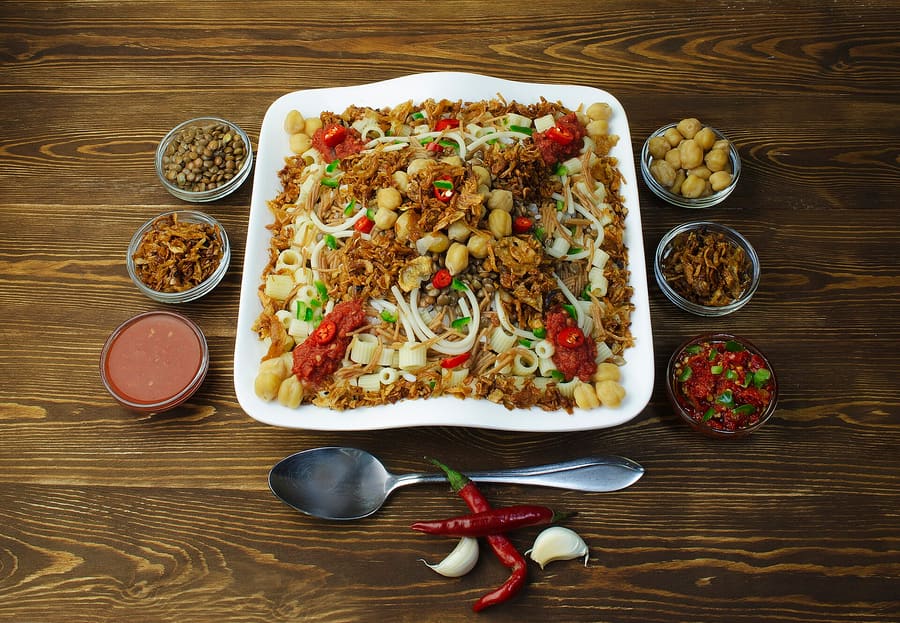 A bowl of traditional Cairo koshary served with garlic vinegar.