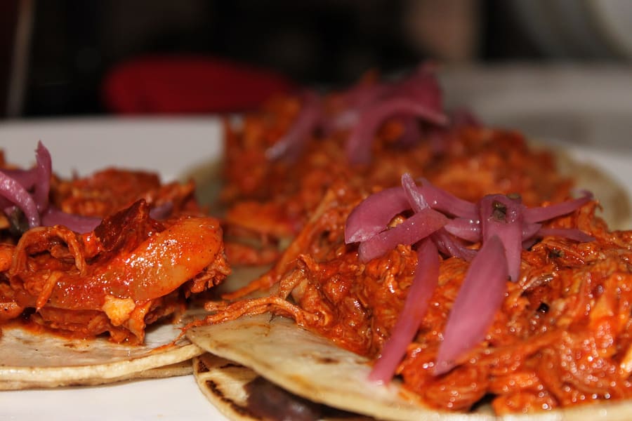 Panuchos topped with turkey, cabbage, and pickled red onion.