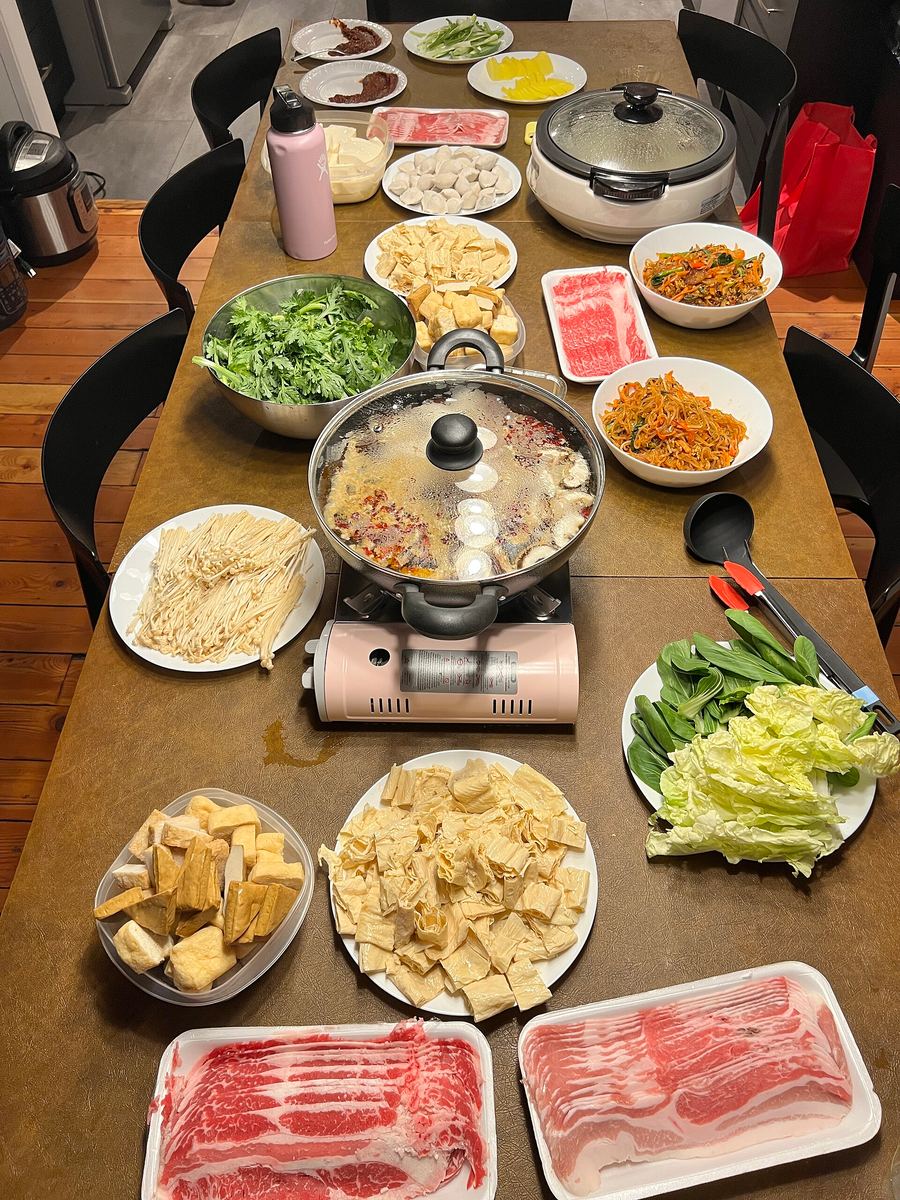 Traditional hotpot served in a segmented iron vessel with heavy beef tallow and dried red chillies.