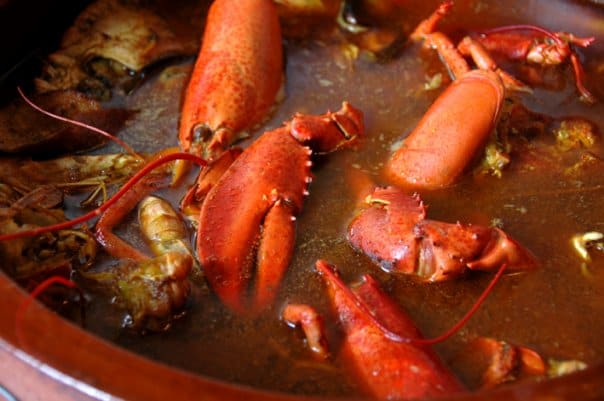 Fresh lobster stew prepared in a traditional terracotta casserole.