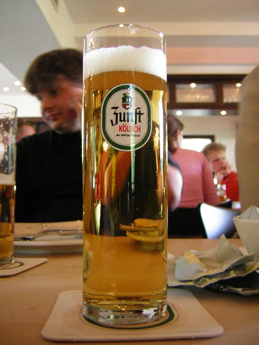 A metal Kranz tray carrying fresh 0.2-litre Stangen glasses in a traditional Cologne tavern.