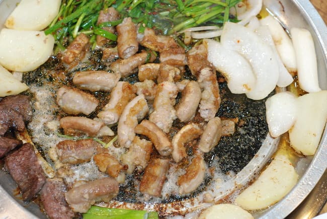 Grilled pork entrails (makchang) sizzling over charcoal at Anjirang Market.