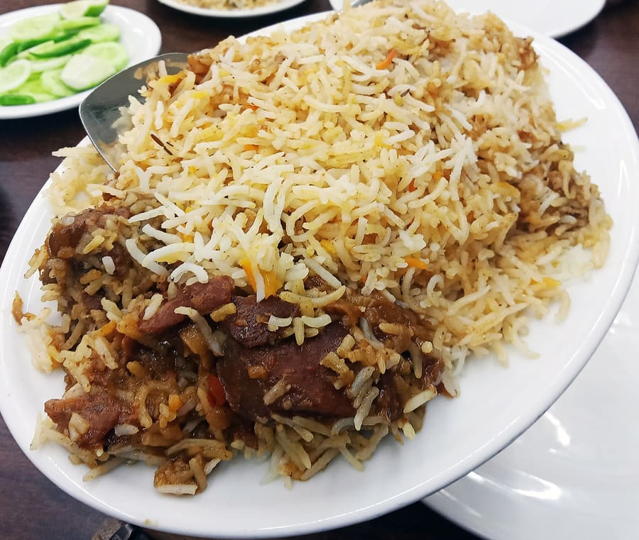 Mutton Kacchi Biryani served with marinated potatoes at a traditional Dhaka diner.
