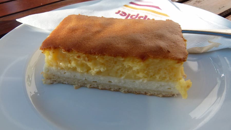A sliced Dresdner Eierschecke served with coffee at a local bakery.