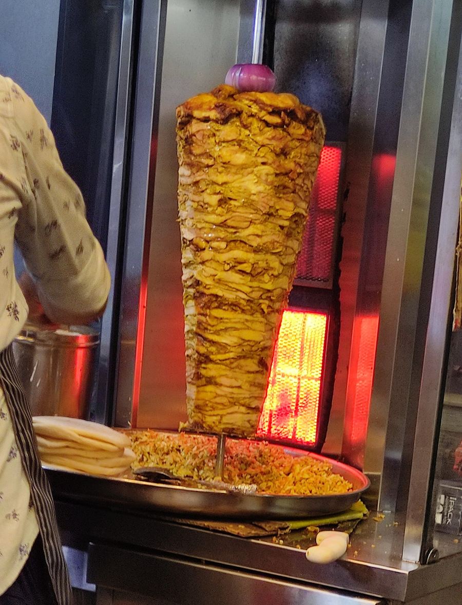 Chicken and mutton shawarma spitted and shaved fresh at street counters across Deira.