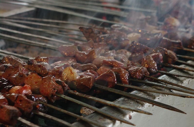 Tava ciğer served with dried fried peppers and sliced onions.