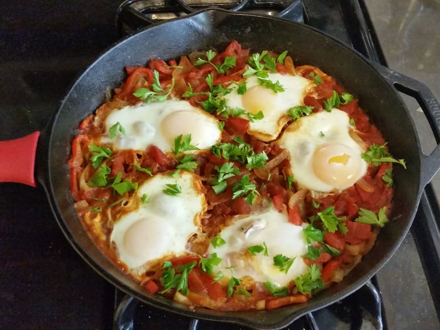 Shakshouka served hot in a skillet, a popular breakfast choice across local cafes.