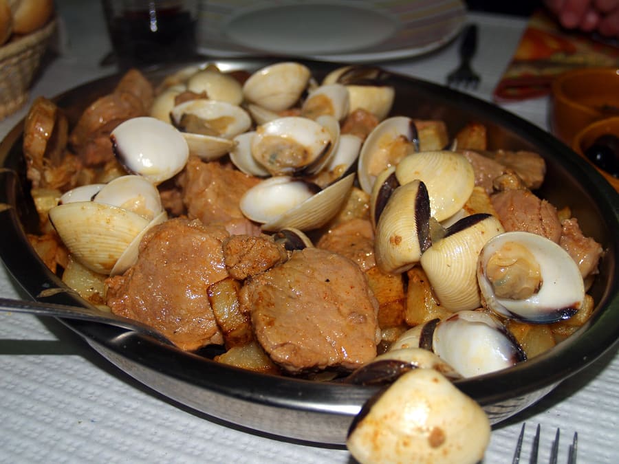 Carne de porco à alentejana: marinated pork fried with clams, potatoes, and fresh coriander.