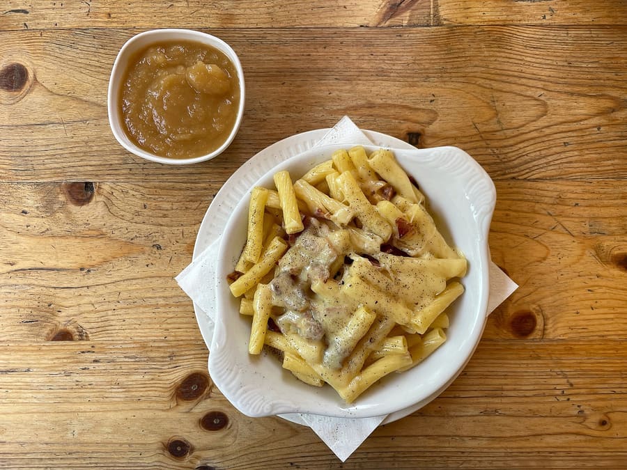 Älplermagronen served in a traditional pan with stewed apples.