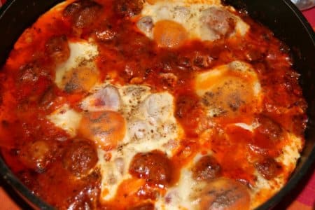 Ojja served hot with peppers, olive oil, and poached eggs.