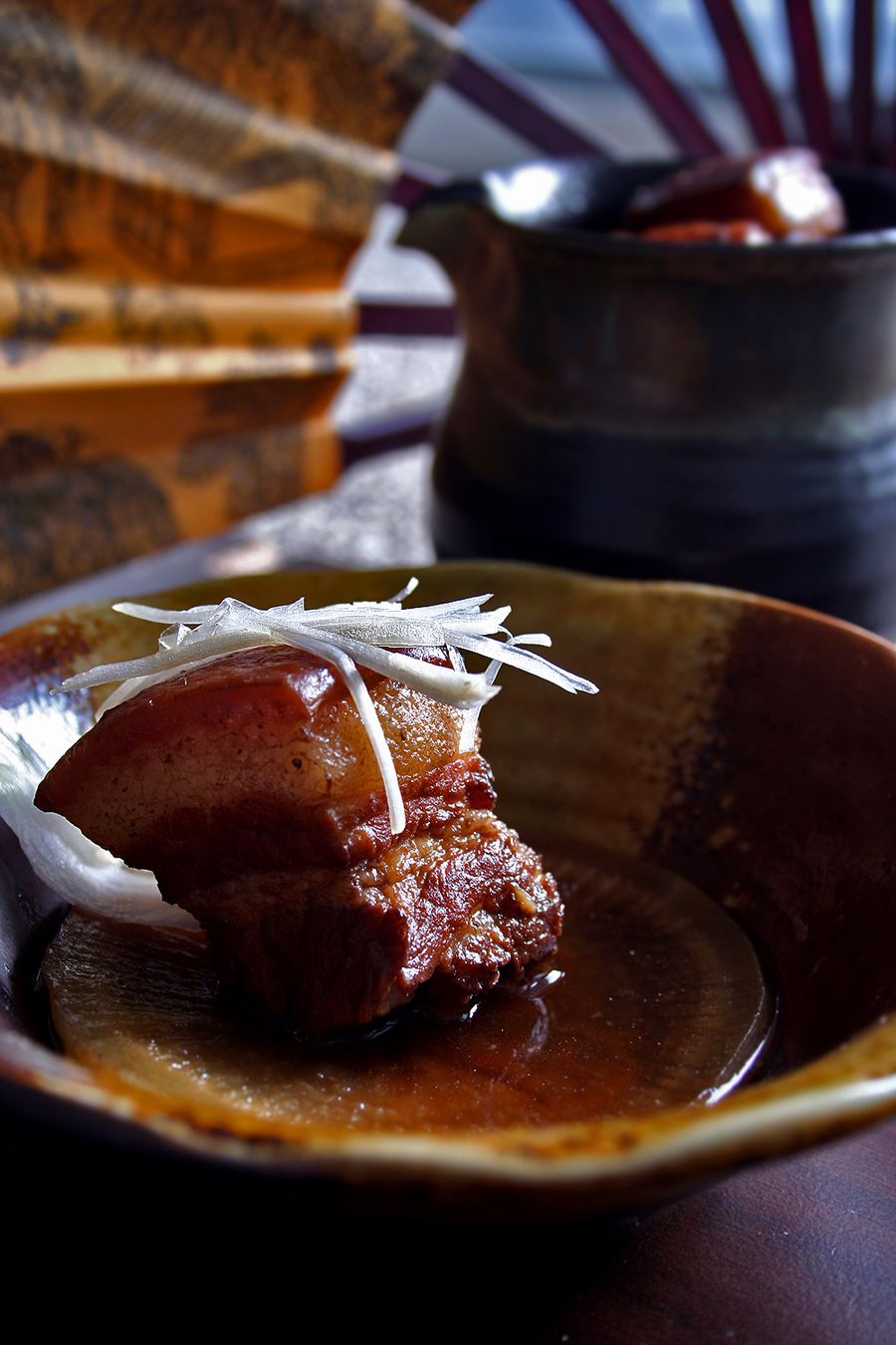 Dongpo pork braised slowly with Shaoxing wine inside a clay pot.