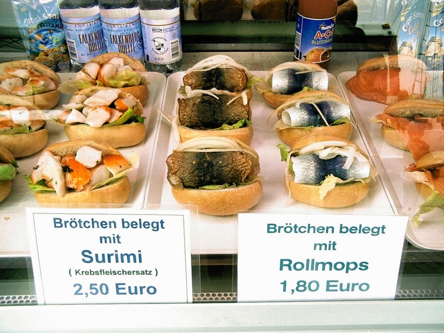 A fresh Bismarck herring roll with onions, served at a beachside smokehouse.