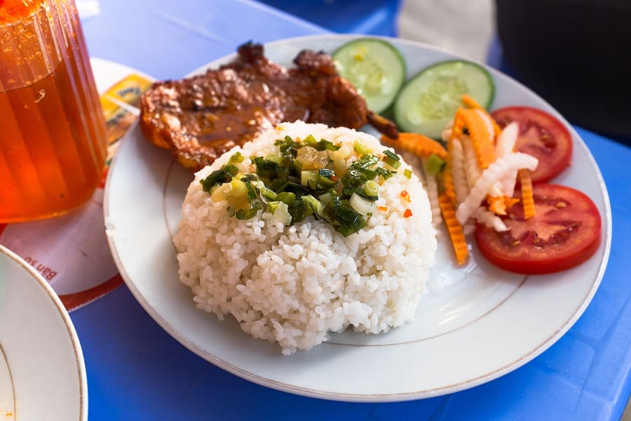 Cơm tấm served with grilled pork chop, steamed egg loaf, and pickled vegetables.