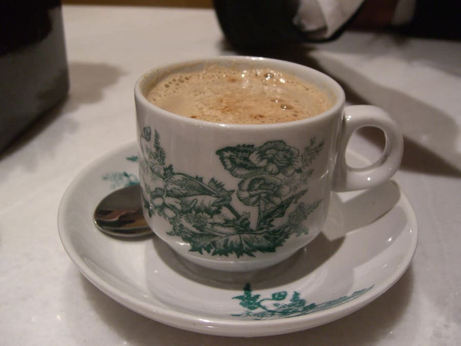 Traditional Ipoh white coffee served in a classic thick-rimmed porcelain cup.
