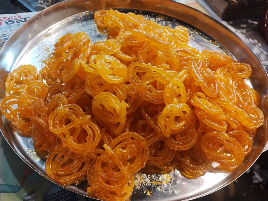 Khoya jalebis are fried until dark brown before soaking in warm cardamom syrup.