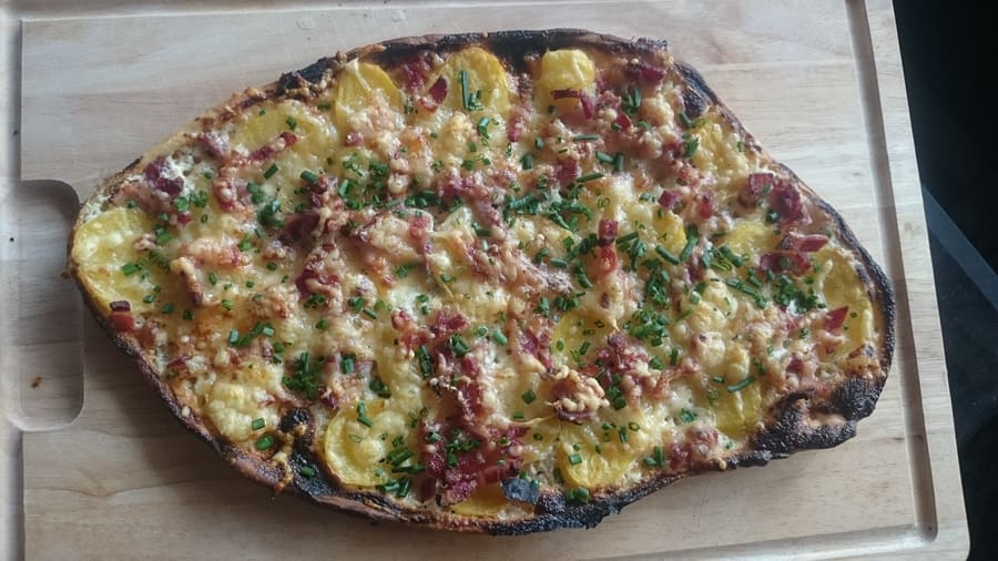 Dinnele, cooked in high-heat wood ovens, served on wooden boards.