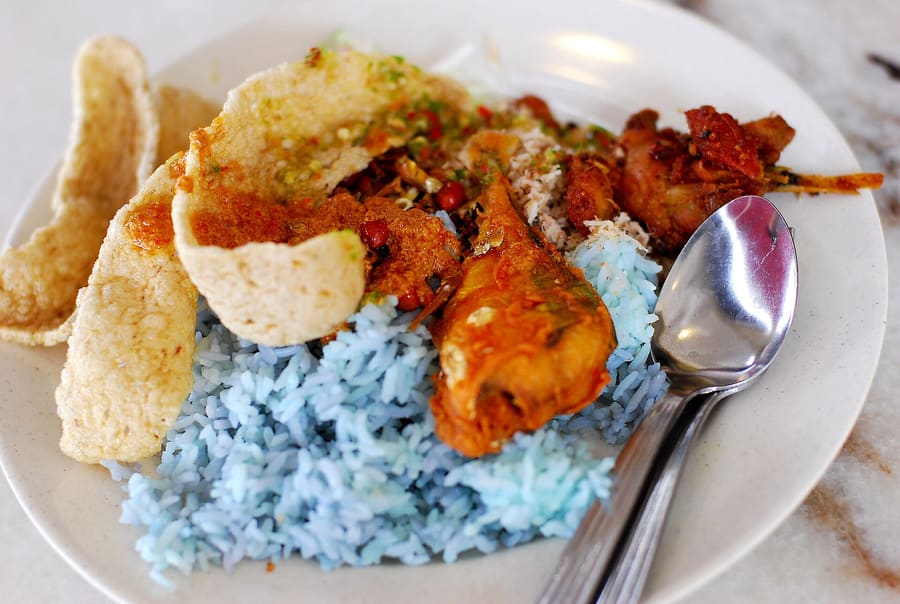 Nasi kerabu served with fresh local herbs, solok lada, and fried chicken.