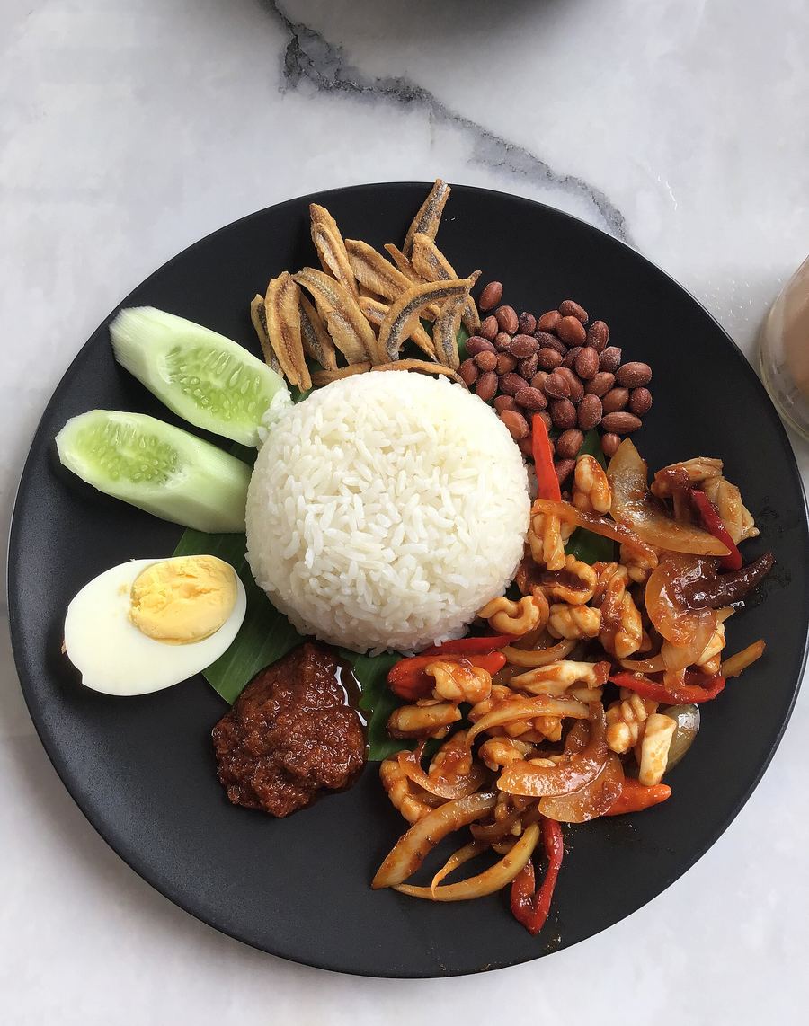 Nasi lemak served with sambal, anchovies, peanuts, and boiled egg.