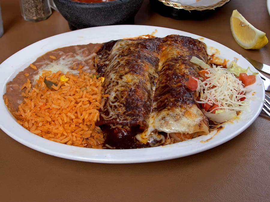 Stacked red chile enchiladas served with a fried egg on top.