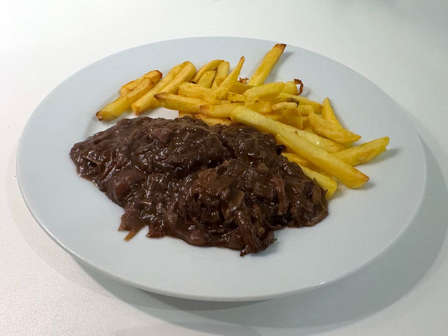 Zoervleis (zuurvlees) served with traditional thick-cut fries and mayonnaise.