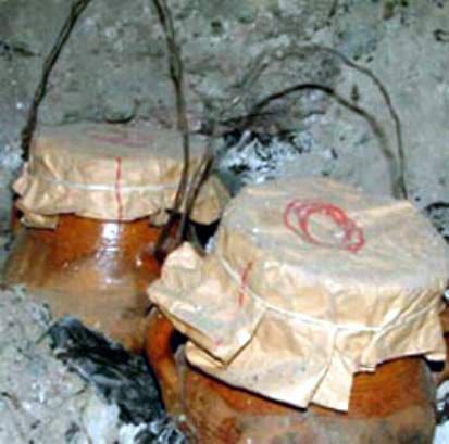 Slow-cooked tanjia clay pots roasting in communal ash furnaces.
