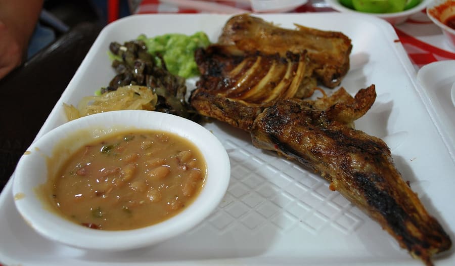 Cabrito roasted slowly over mesquite wood embers at a traditional Regiomontano restaurant.