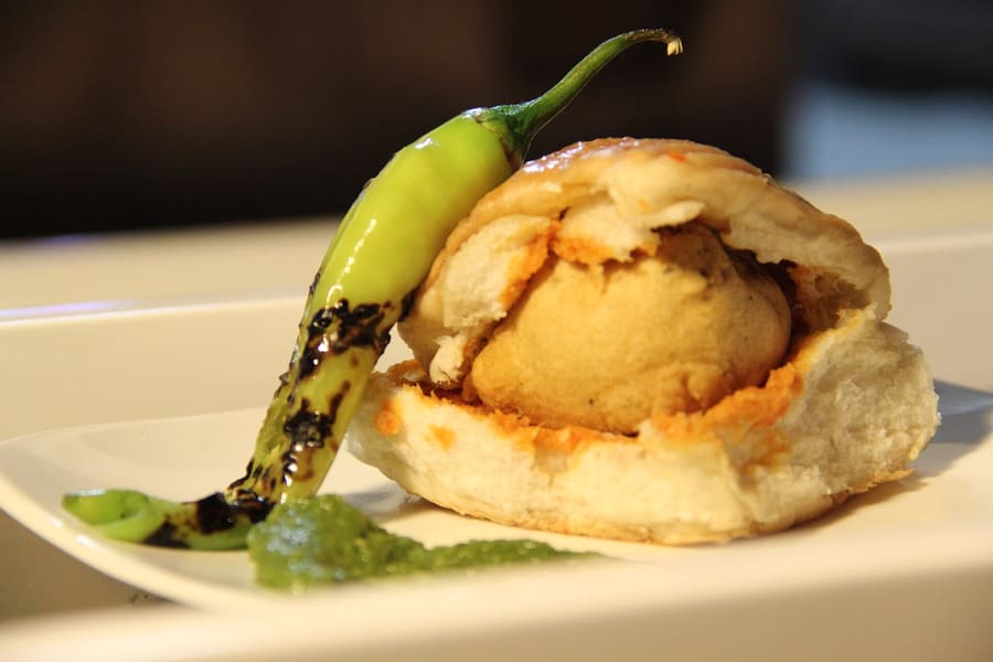 Vada pav served fresh with salted green chilli and fried garlic chutney.