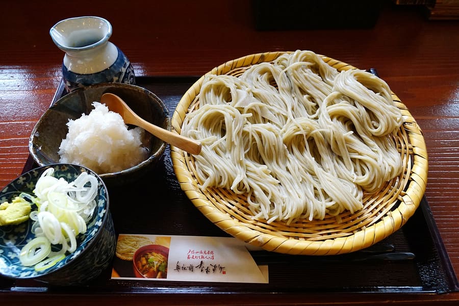 Togakushi soba served in horseshoe-shaped coils on a round bamboo mat.