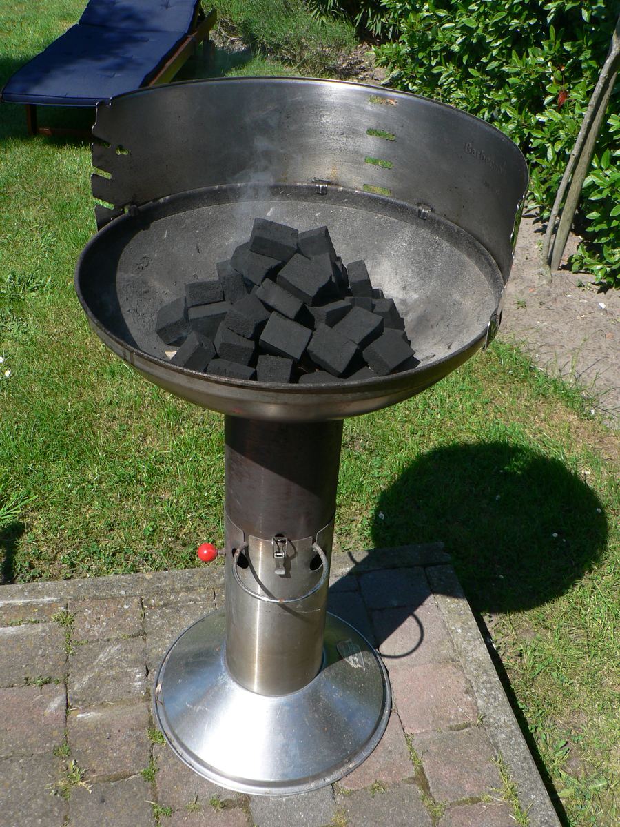 Open-wood braai fire cooking boerewors sausage and steak.