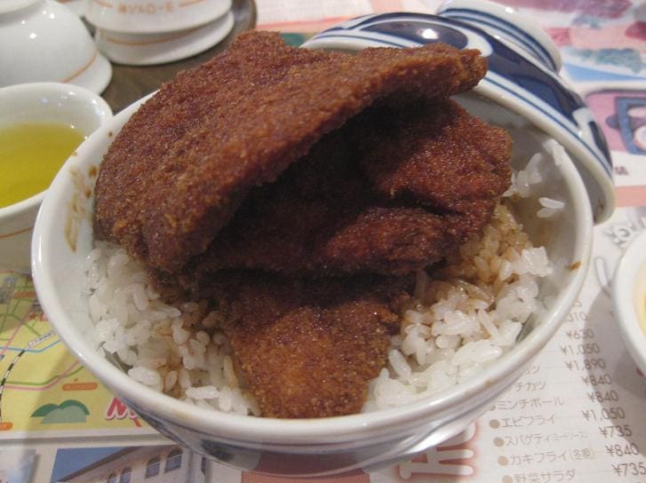 Tarekatsu-don features thin soy-glazed pork cutlets layered over steamed Koshihikari rice.
