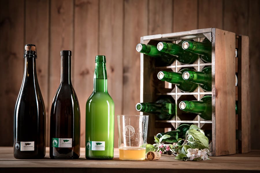 Natural cider poured high into wide glasses on Calle Gascona