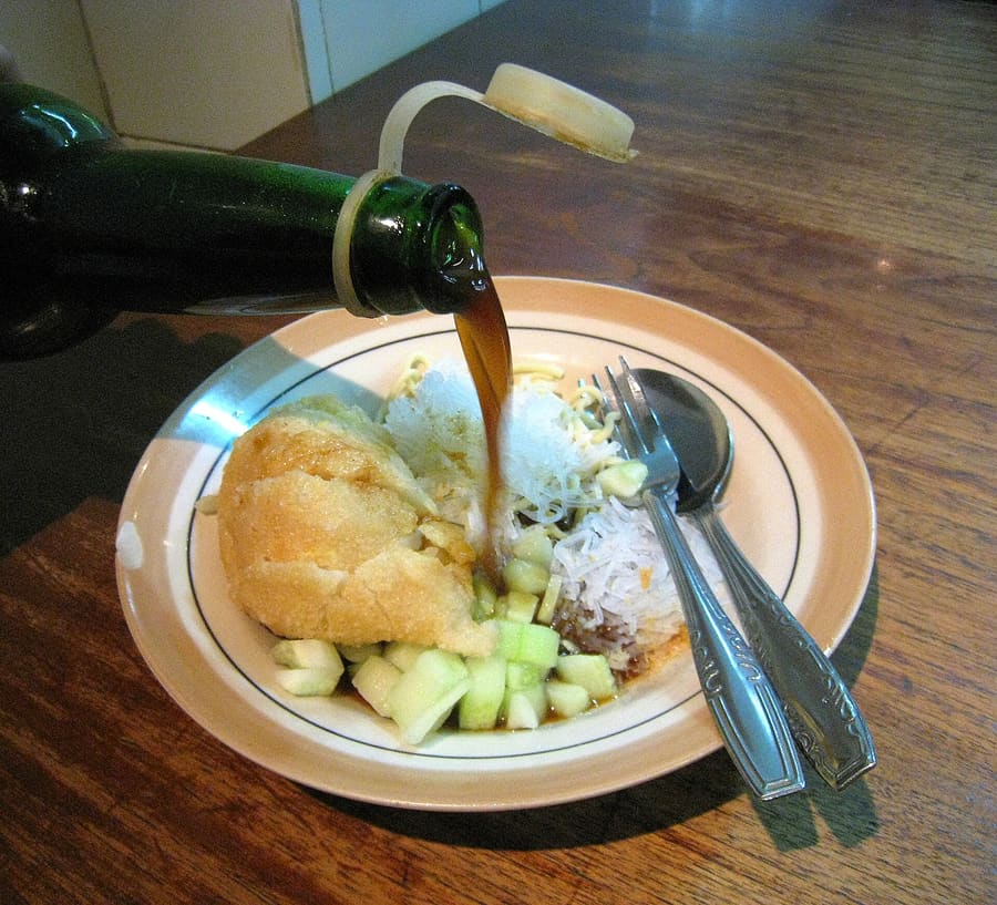 Pempek kapal selam stuffed with egg, served alongside dark vinegar cuko sauce.