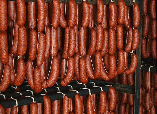 Chorizo Santarrosano served hot with lime and a small corn arepa.