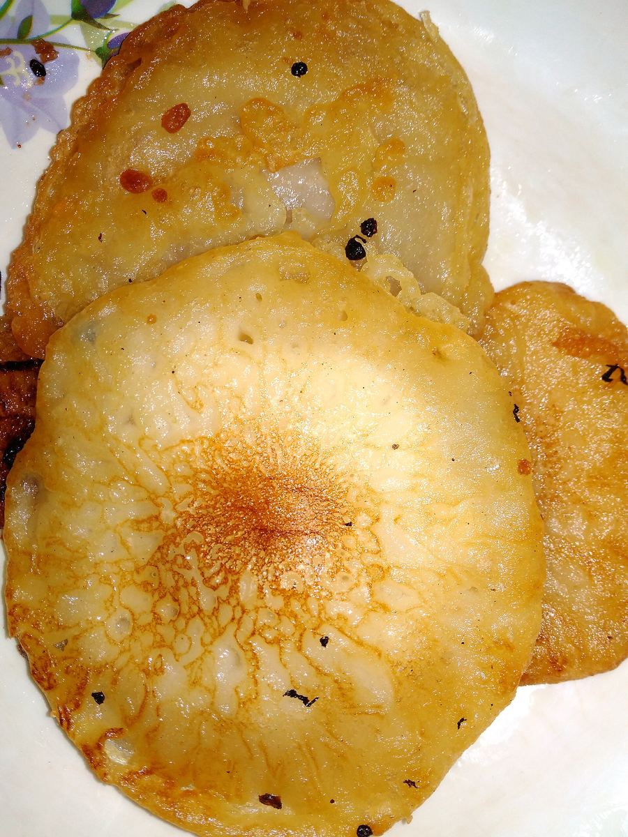 Freshly fried malpua sweet soaked in hot sugar syrup on Halwai Gali.