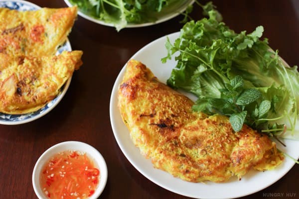 Bánh xèo tôm nhảy served sizzling with crisp bean sprouts and fresh herbs.