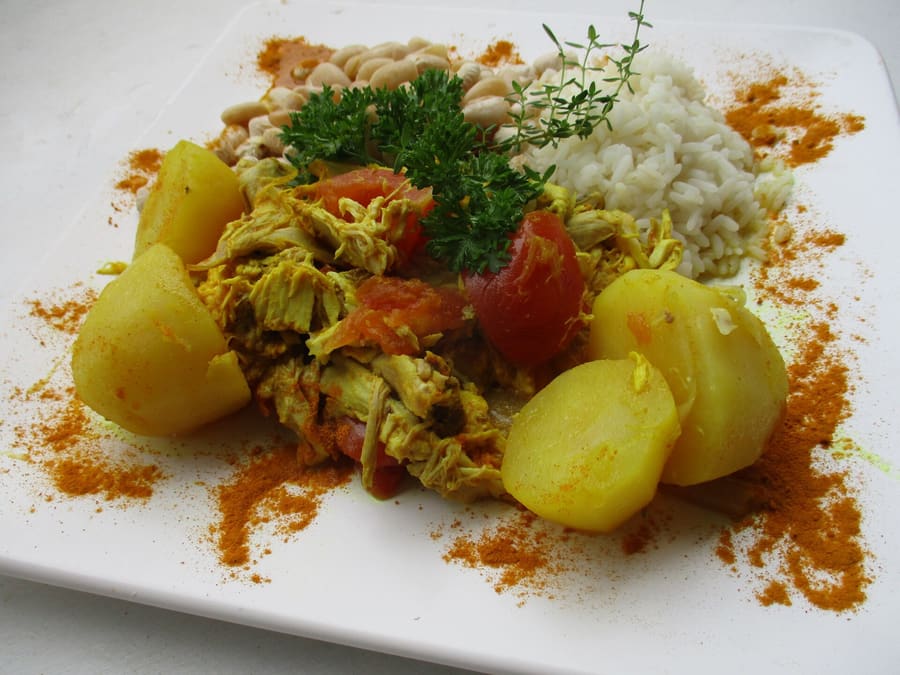 A traditional cari served with rice, pulses, and chili rougail.