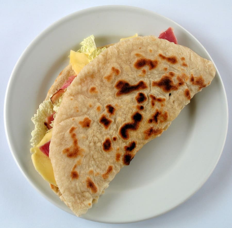 Freshly griddled piadina folded with squacquerone cheese and prosciutto crudo.