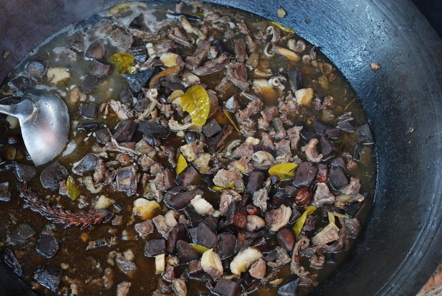 Thắng cố, a traditional horse meat and offal stew cooked in a broad iron pan.