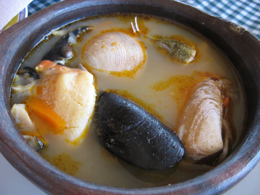 Fresh paila marina seafood soup served in a traditional clay bowl.