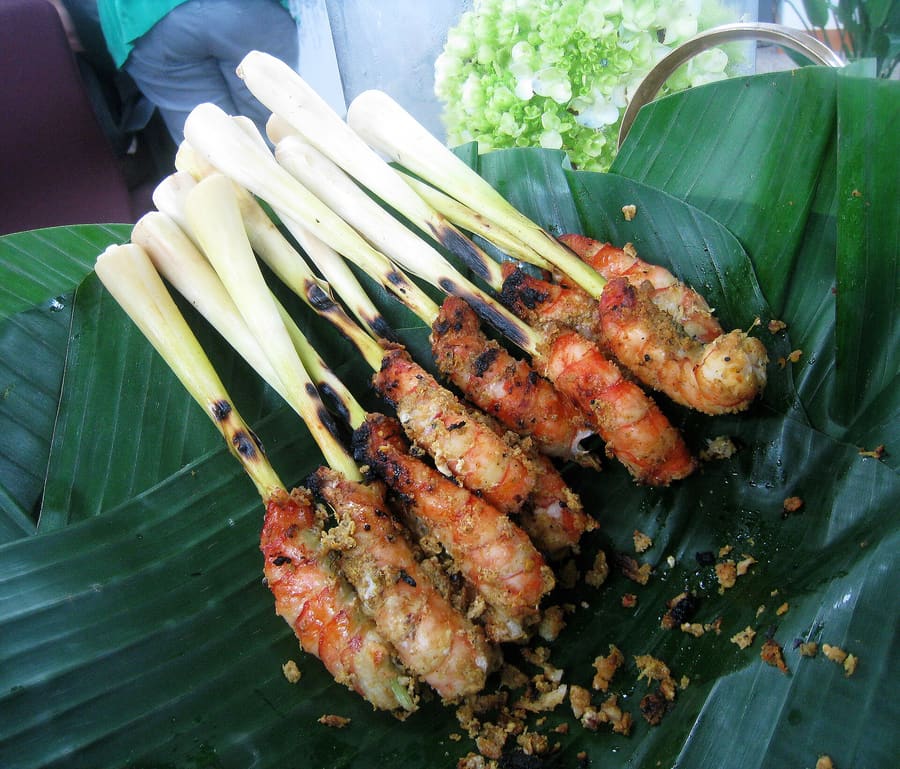 Satay skewers served with peanut dip and rice cakes.
